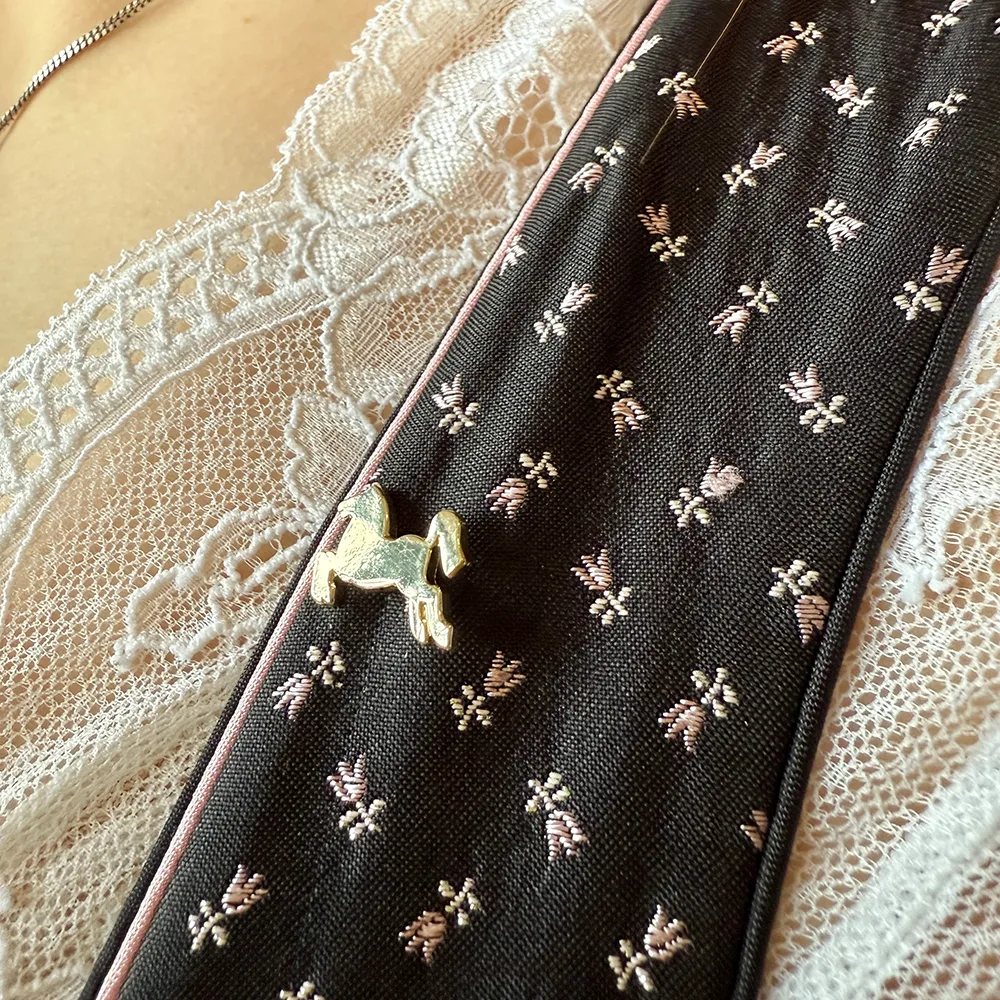 Ansteck-Pin in Form eines Goldenen Pferdes an einem Dirndl, Detailaufnahme